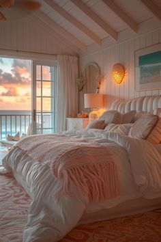 a bedroom with an ocean view is shown in this image, the bed has white linens and pillows on it