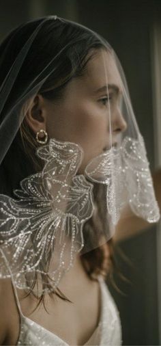 a woman wearing a veil and earrings