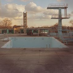 an empty swimming pool in the middle of a parking lot with stairs leading up to it