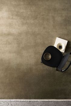 a black chair sitting on top of a floor next to a toilet paper dispenser