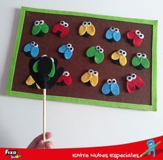 a child's hand is holding a popsicle in front of a bulletin board