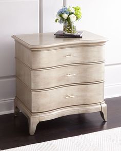 a white dresser with flowers on top of it