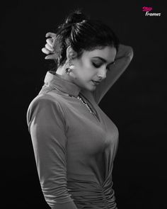 black and white photograph of a woman with her hand on her head, looking down