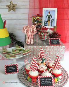 a table topped with lots of cupcakes and candy