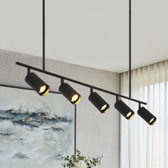 three lights hanging from the ceiling in a living room