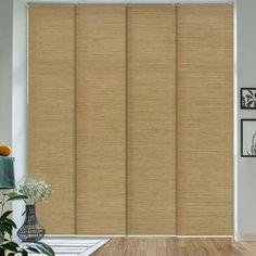 a living room scene with focus on the sliding glass door and wood flooring that has been made to look like bamboo blinds