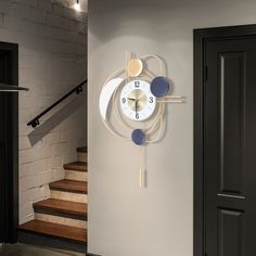 a clock mounted to the side of a wall next to a stair case and door