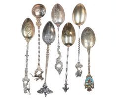 an assortment of silver spoons with ornate designs