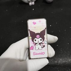 a person wearing white gloves holding a cell phone case with a cartoon character on it