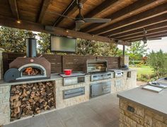 an outdoor kitchen with wood burning ovens