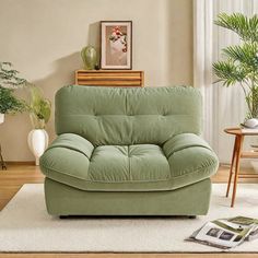 a living room scene with focus on the couch and chair in the foreground, there is a potted plant next to it