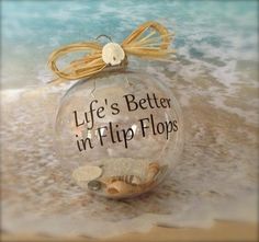 a glass ornament that says life's better in flip flops on the beach