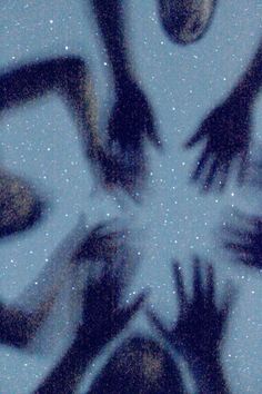 several hands reaching up into the air in front of a snowflaked background