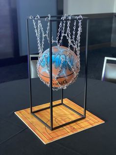 a basketball in a display case with chains hanging from it's sides and on top of a wooden table