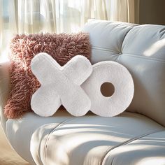 the pillows are made to look like x and o on top of each other in front of a couch