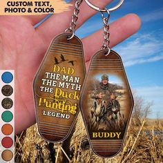 a hand holding two key chains with an image of a man and his dog on them