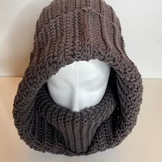 a white mannequin head wearing a brown knitted hat