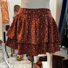 This Adorable Skirt Features Two Layers Of Tiered, Corduroy Floral, And Elastic Smocking In The Back For A Great Flexible Fit Floral Print Skirted Bottoms For Fall, Cotton Skirted Bottoms For Fall, Fall Cotton Skirted Bottoms, Skirted Cotton Bottoms For Fall, Fall Skirted Cotton Bottoms, Cotton Mini Skirt For Fall, Fall Cotton Mini Skirt, Non-stretch Cotton Skirt For Fall, Floral Print Non-stretch Mini Skirt