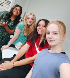 three girls are posing for the camera in front of a window