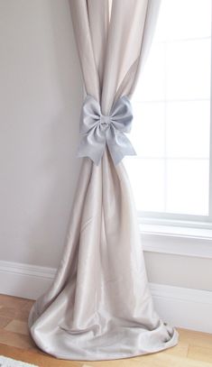 a curtain with a bow on it in front of a window