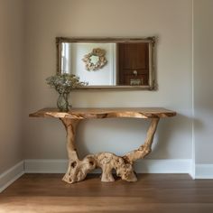 a wooden table sitting next to a mirror on top of a wall in a room