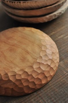 three wooden plates sitting on top of a table next to each other with holes in them