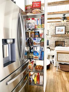 a stainless steel refrigerator in a kitchen with wood flooring and exposed beams on the ceiling