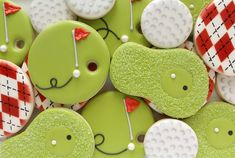 green decorated cookies with white and red designs on them are arranged in the shape of golf balls