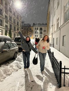 two women walking down a snowy street at night