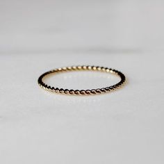 Super cute, minimal gold filled roped stacking ring. This ring features a delicate 1mm twisted band. It is water friendly but note- it is dainty and meant to pair with others for added durability. Available in whole sizes 5-9. Materials: 14k Gold Filled Band Width: 1mm Hypoallergenic. Nickel and lead free. What does Gold-Filled mean? Gold filled jewelry contains 1/20th (5%) of real gold content, or more than 100x real gold content that most gold plated jewelry. The process to make gold-filled je Minimalist Twisted Rings For Everyday Wear, Minimalist Twisted Rings For Everyday, Minimalist Twisted Everyday Rings, Minimal Gold, Twisted Band, Plated Jewelry, Stacking Ring, Gold Filled Jewelry, Gold Plated Jewelry