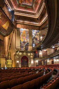 the inside of an auditorium with red seats