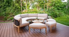 a couch and ottoman on a deck with trees in the backgroung area