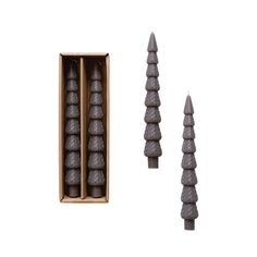 three candles are in a box and one is made out of wood, the other two are shaped like cones