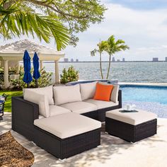 an outdoor couch and ottoman next to a swimming pool