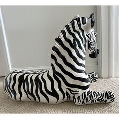 a zebra statue sitting on the floor next to a door