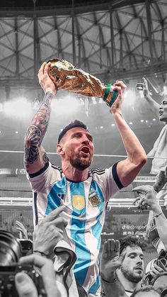 a soccer player holding up a trophy in front of his head while surrounded by fans