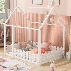 a child's room with pink walls and white furniture, including a doll house bed