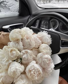 a bunch of white flowers sitting inside of a car