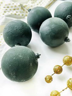 some green and gold ornaments on a white table