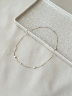 This delicate mixed Pearl chain necklace is minimal yet unique and puts a modern twist on a classic Pearl necklace! The genuine white Pearls are unevenly distributed on the sparkly dainty chain. This is a beautiful piece that is sure to get you many compliments! * 14K Gold Filled or 925 Sterling Silver chain & dainty spring clasp * Choose from 16"-18" or 18"-20" length * 3mm-5mm Freshwater Pearls * 14/20 gf or 925 stamp for authenticity * Made with 100% hypoallergenic materials See all Pearl Jew Delicate White Necklace For Everyday Elegance, Modern White Chain Necklace For Everyday, Modern White Pearl Necklace, Dainty Cable Chain Necklace For Wedding, Delicate 14k Gold Necklaces For Everyday Elegance, Everyday Delicate Pearl Chain Necklace, Modern White Jewelry With Delicate Chain, Dainty Single Strand White Chain Necklace, Minimalist Everyday Single Strand Chain Necklace