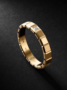 a gold wedding band with diamonds on the inside and outside, sitting on a black surface