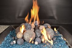 an outdoor fire pit with rocks and gravel in the center, lit by bright flames