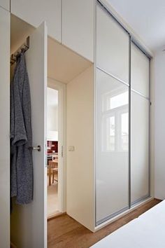 a bedroom with white walls and sliding glass closet doors that open up to the bed