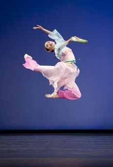 a woman in white and pink dancing on stage