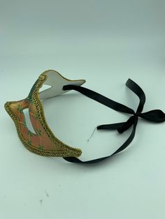 "This is a very nice original handmade and hand painted Venezia masquerade face mask made in Italy. The design on the shiny gold and orange face mask features turquoise blue and multi-color glitter with a border of gold lace and gold rope around the edges. It comes with a black ribbon tie and is stamped on the back \"Original Hand Painted Made in Italy Venezia\". The mask measures approximately 6 5/8\" long and 3 3/4\" wide and is in very good preowned condition with light wear on the back of th Green Carnival Masks And Prosthetics, Adjustable Full Face Mask For Masquerade, Halloween Eye Mask As A Gift, Halloween Eye Mask Gift, Green Mask For Masquerade Carnival, Green Masquerade Mask For Mardi Gras, Green Masks For Masquerade Carnival, Green Masks For Carnival Masquerade, Handmade Masquerade Mask For Carnival Halloween