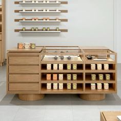 a kitchen with wooden cabinets and shelves filled with food on top of each shelf in front of a white wall