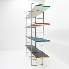 a multicolored shelf sitting on top of a white floor next to a wall