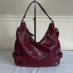 Gorgeous Hobo Bag From Michael Kore Done In A Rich Burgundy Leather With Accent Stitching And A Belted Design On The Ends At The Lower Half Of Bag. Top Zipper With Silver Hardware. Interior Is Done With The Signature Canvas Fabric With Leather Trimmed Large Slip Pockets, A Zippered Pocketed Two Smaller.Slip Pockets. It Also Has A Leather Lanyard For Keeping Keys Handy. Measures 13" X 12" X 2" With A 7" Strap Drop. The Bag Is In Near Perfect Condition With A Few Fingernail Scratches Front And Bac Red Hobo Bag, Leather Lanyard, Signature Canvas, Leather Hobo Bag, Leather Hobo, Cole Haan, Hobo Bag, Leather Trims, Canvas Fabric