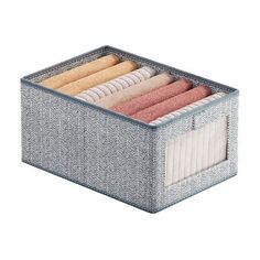 an organized storage box filled with towels and folded napkins on top of each other