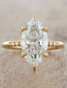 a yellow gold ring with an oval cut diamond